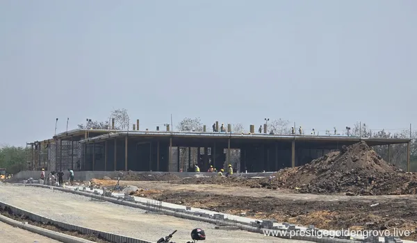 The sales gallery / experience centre under construction at Prestige Golden Grove, with columns, roof slab and workers on site.