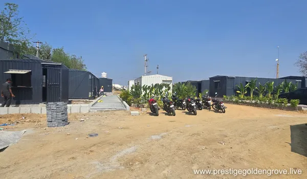 On-site office cabins (modular container units) with staff motorcycle parking and landscaping at Prestige Golden Grove, Velimela.