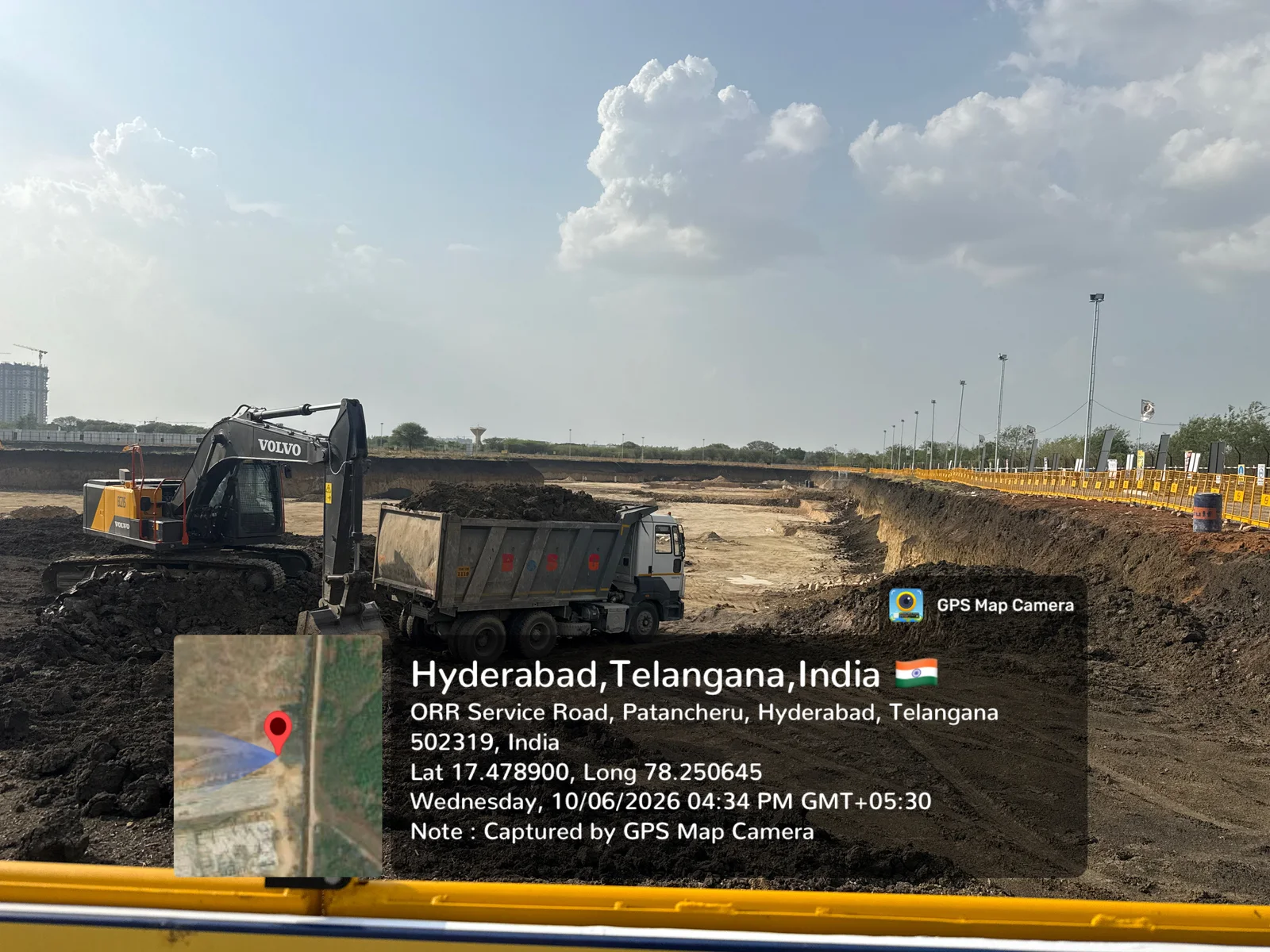 Active deep excavation at Prestige Golden Grove with a Volvo excavator loading a tipper truck, Velimela-Kollur, June 2026.