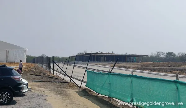 Panoramic view of the vast 28.7-acre Prestige Golden Grove construction site in Velimela-Kollur, Hyderabad, showing initial land leveling and boundary fencing during the pre-launch phase.