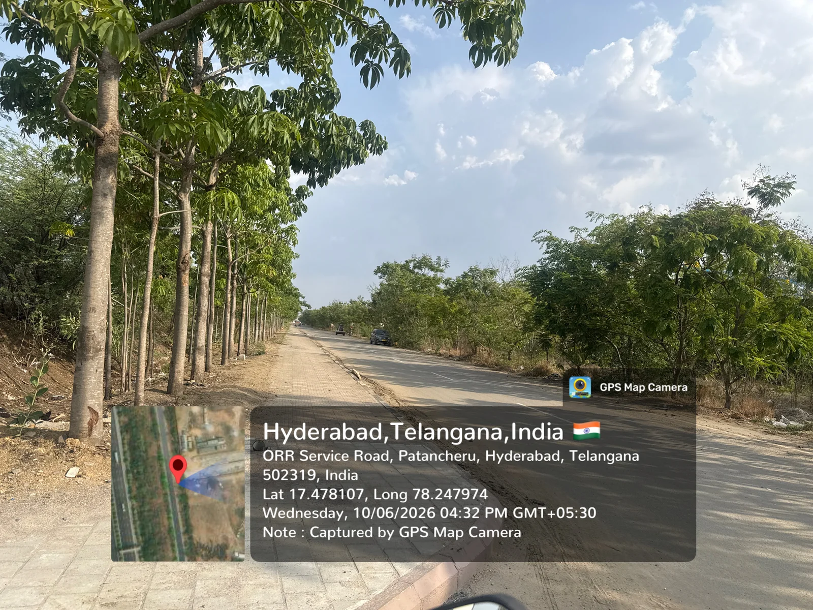 The tree-lined ORR Service Road approach to Prestige Golden Grove at Velimela-Kollur, near ORR Exit 2, June 2026.