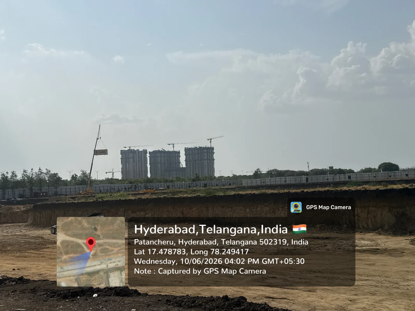 Prestige Golden Grove construction site with the Velimela-Kollur corridor skyline and tower cranes in the background, June 2026.